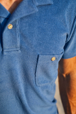 man wearing a blue terry cloth polo