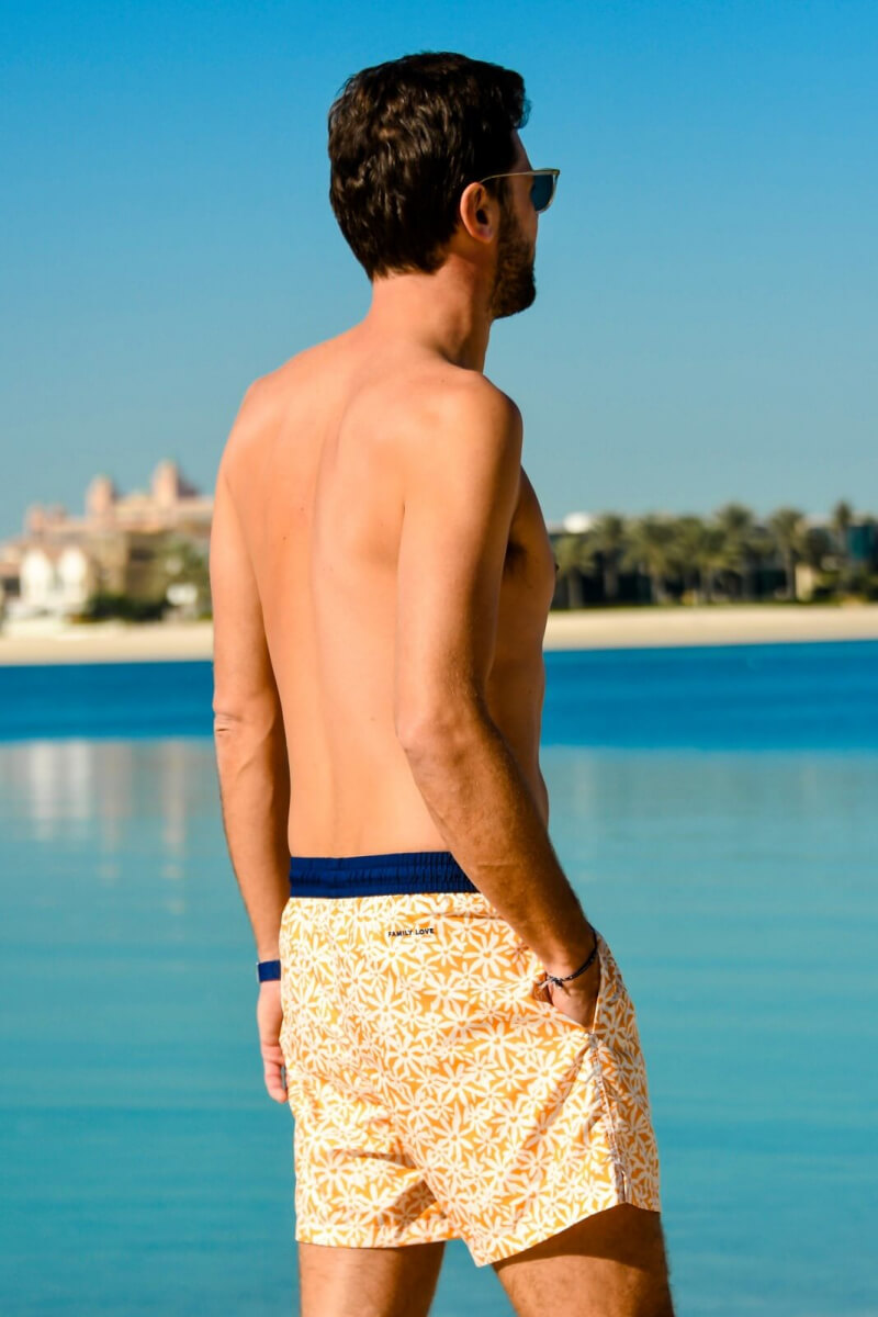 Man wearing a Pâquerettes GILI'S x EMOI EMOI swimsuit with elasticated belt