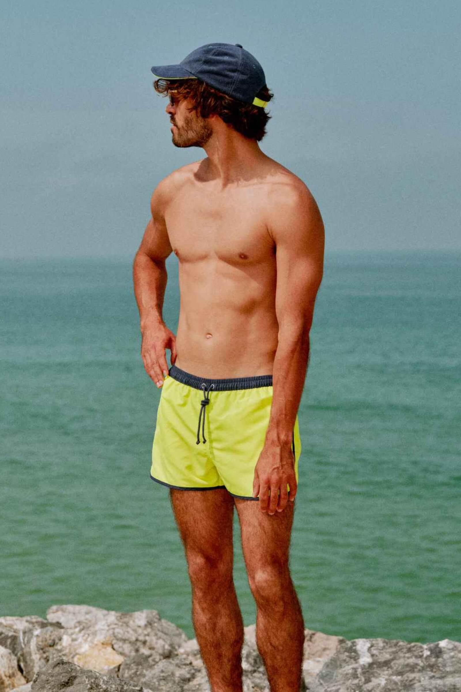 Homme portant un short de bain court Komodo Neon Yellow